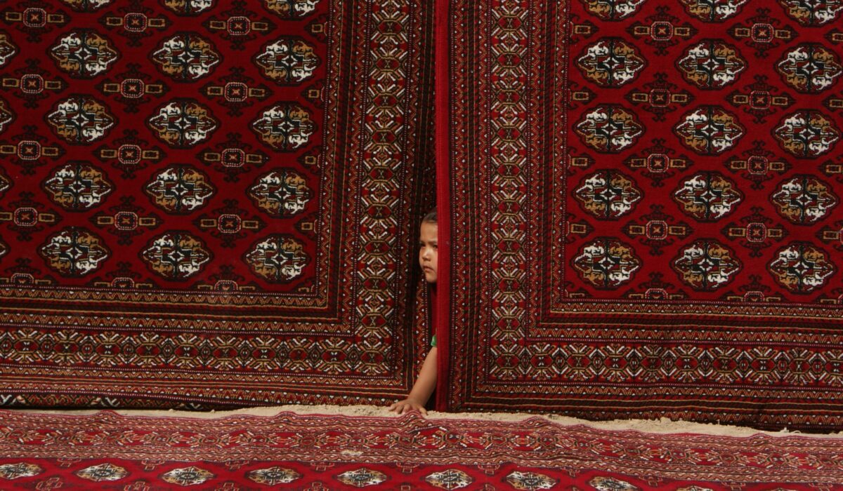 Abel Polese, Carpets – Turkmenistan – Mary oblast’ 2011

A team of researchers (including myself) was invited to a celebration in
a small village. They were offered food, drinks and a spectacle. To our
surprise, the inhabitants of the village were not allowed into the area,
separated by “carpet-fences”. Carpets also covered the entire ground
of the celebration site. This little girl was too curious to see what was
happening inside the carpet village and managed to sneak in.