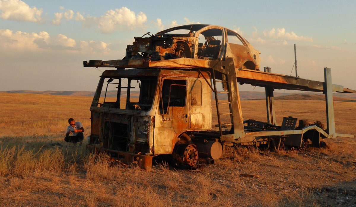 Verena La Mela,  Kazakhstan, 2019, 
Between 2016 and 2019 I studied trade and infrastructure in the SinoKazakh borderlands. As a social anthropologist my method to approach
roads anthropologically was to participate in traffic as a driver.
Female drivers are an unusual sight in rural Kazakhstan. Often I was
confronted with the prejudices of male drivers, corrupt traffic police,
sexual harassment and frequent road accidents or its relics as is shown
on the picture. Death is a constant companion on Central Asian roads.