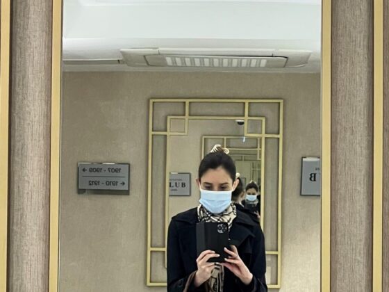 A woman in a face mask reflected in a mirror