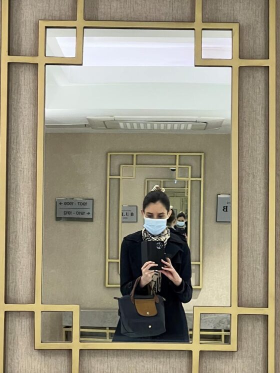 A woman in a face mask reflected in a mirror