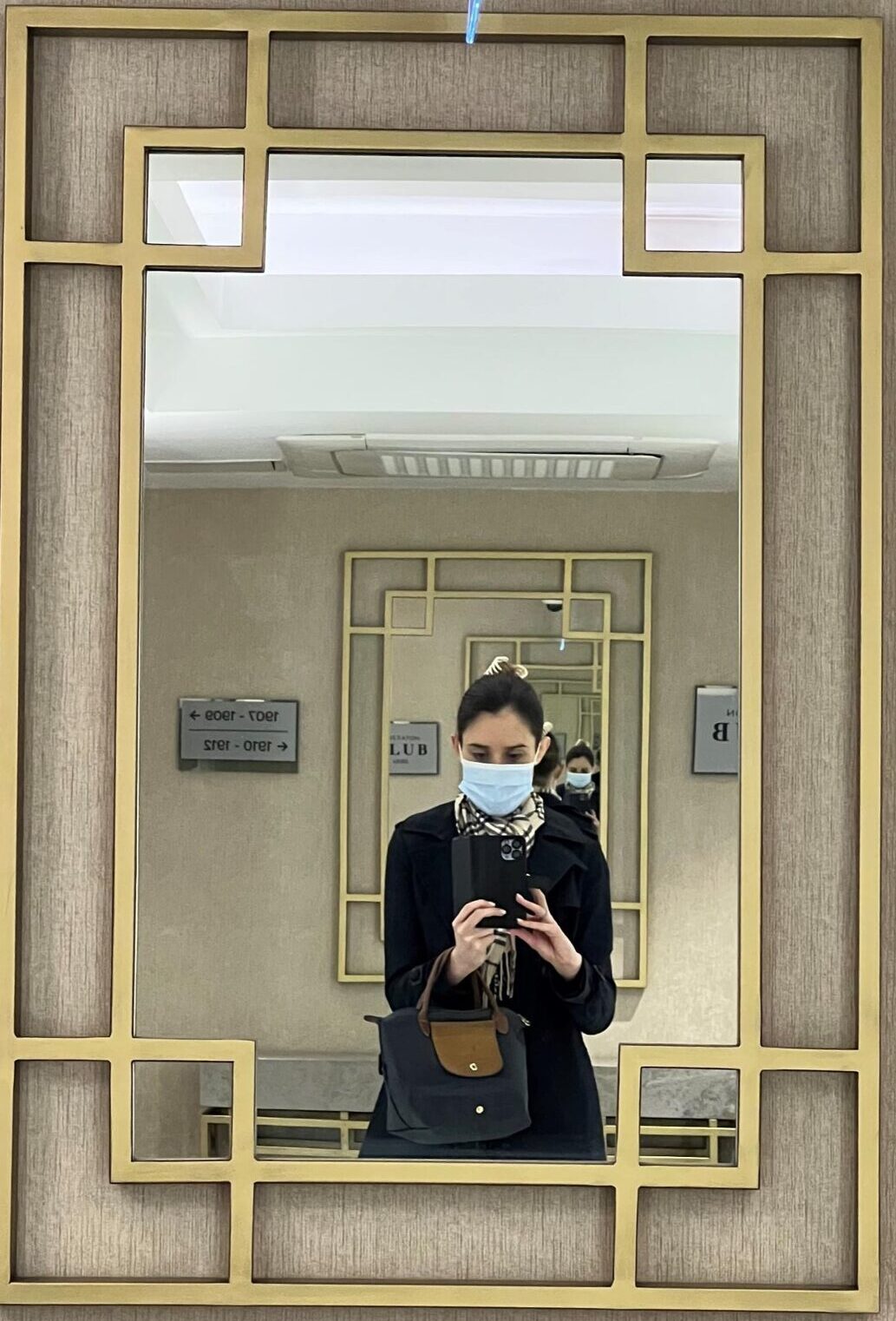 A woman in a face mask reflected in a mirror